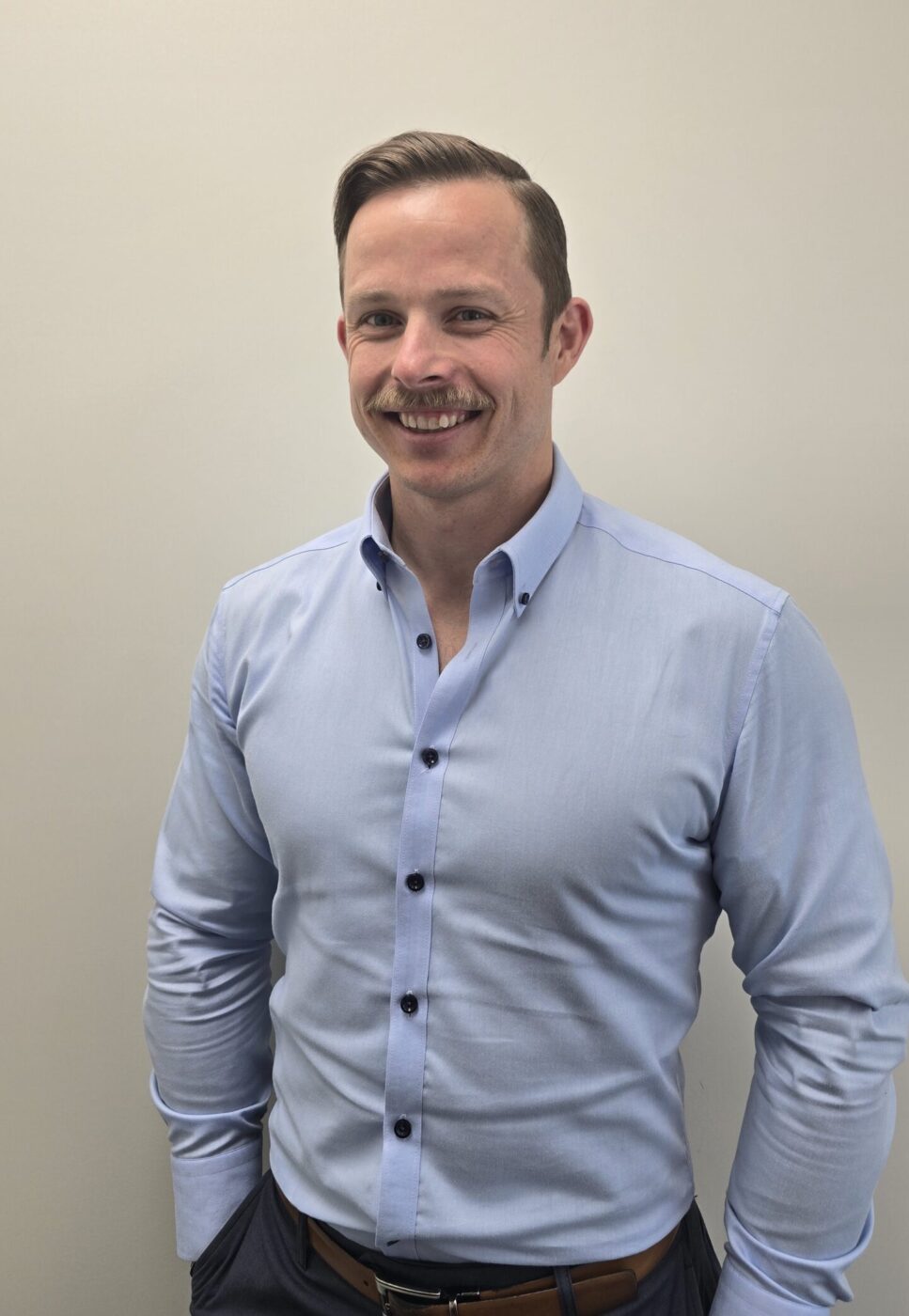 Image of Mark standing with hands in pockets.
